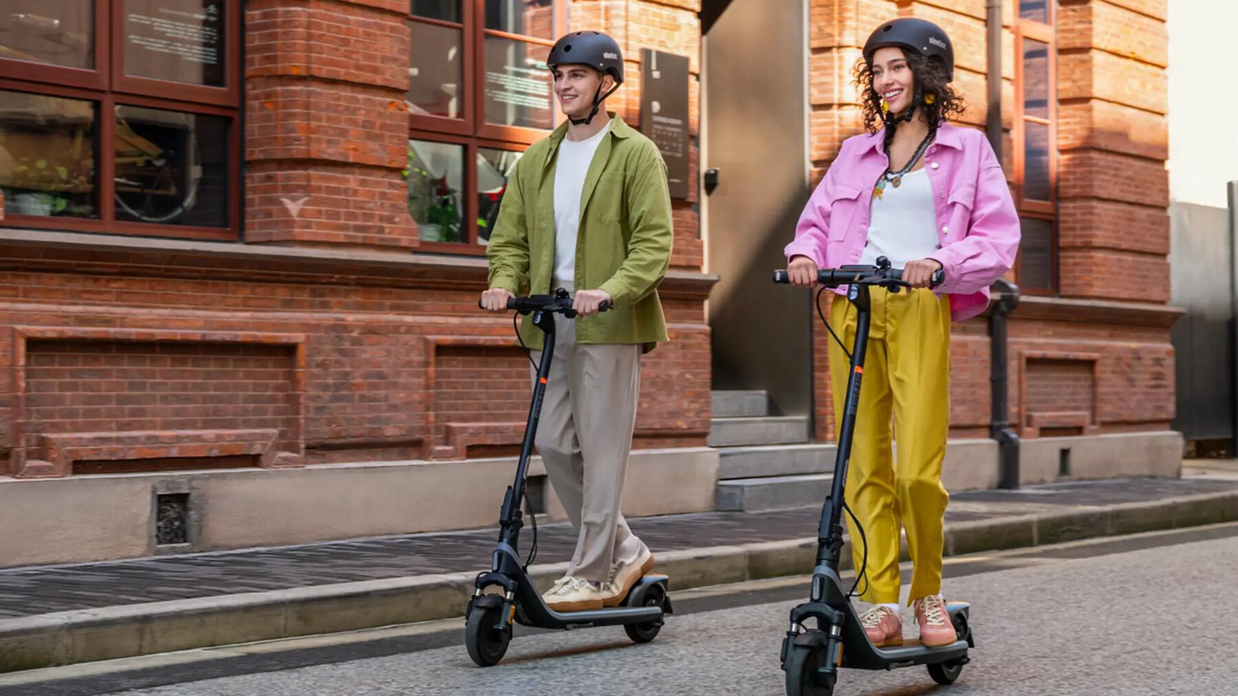 Dos personas en patinetes eléctricos por la ciudad