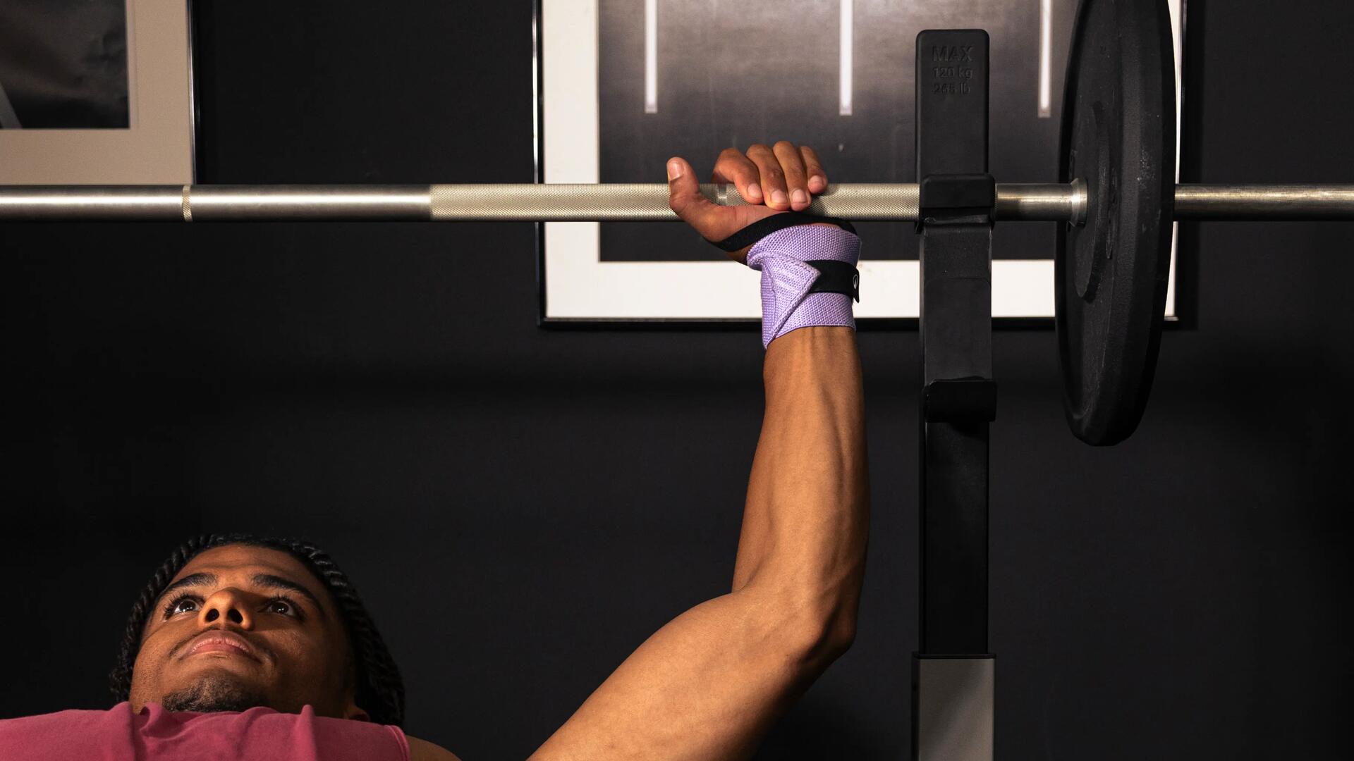 Man die een bench press uitvoert met gewichten op een stang