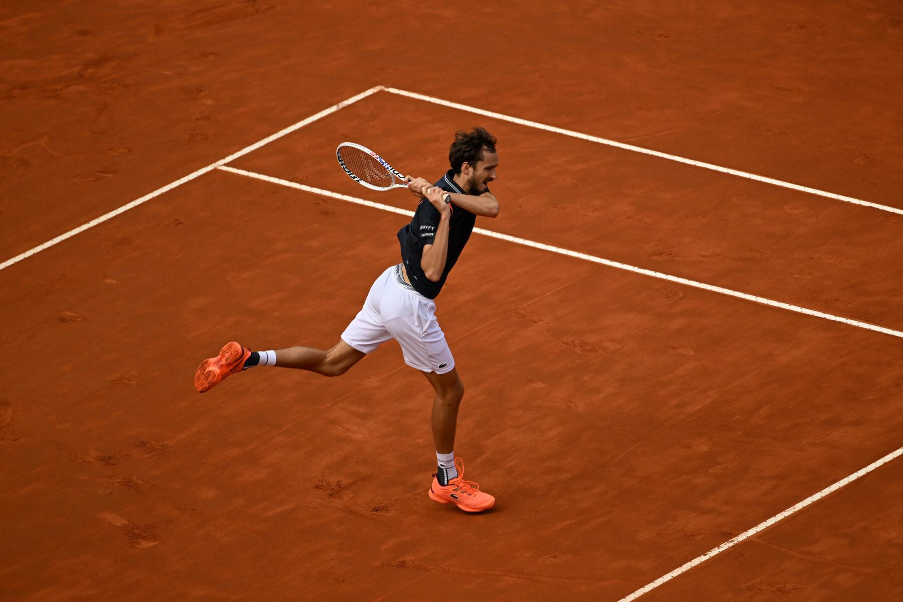 Mann schlägt den Ball mit einem Tennisschläger
