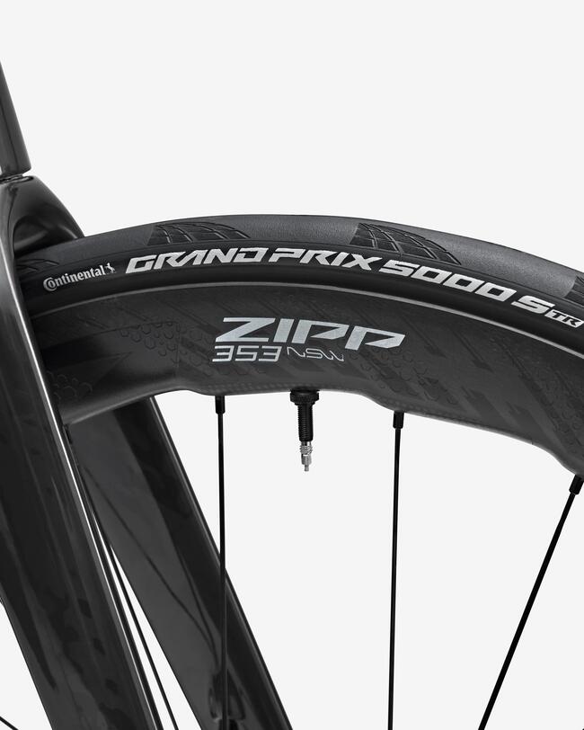 Schwarzes Laufrad mit breiter Felge und weißen Logodetails; schwarze Fahrradgabel