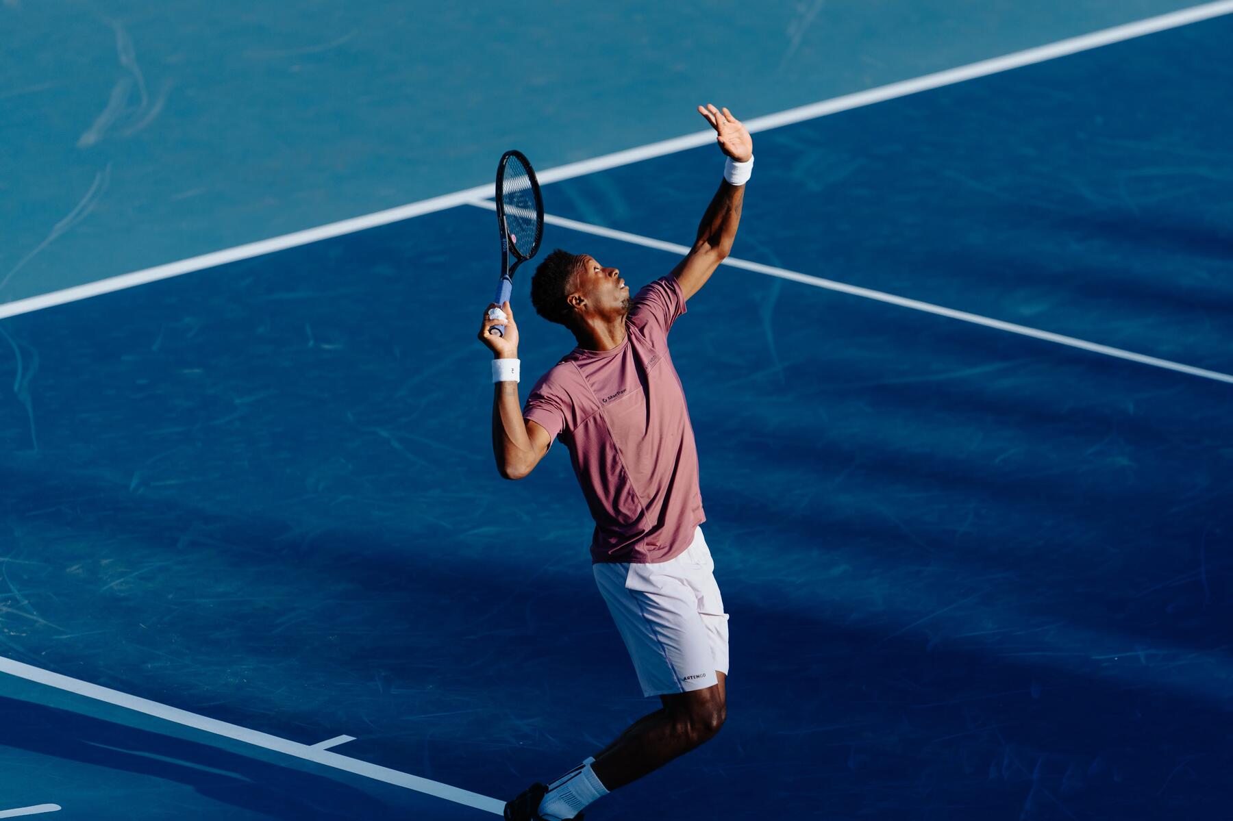 Mann macht mit einem Tennisschläger Aufschlag