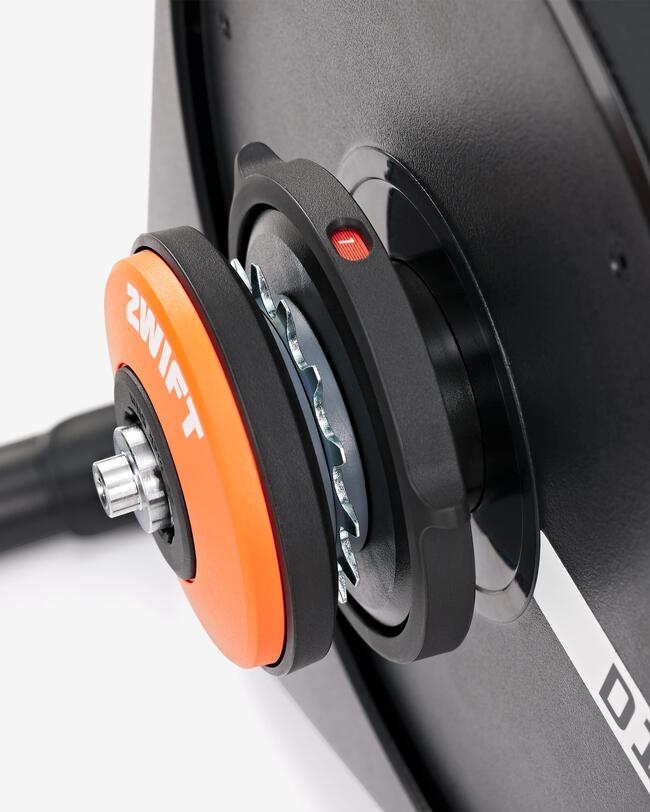 Schwarze runde Trainingsrolle mit auffälligem orangefarbenem Element, glänzende Metallteile und matte Oberflächen.
