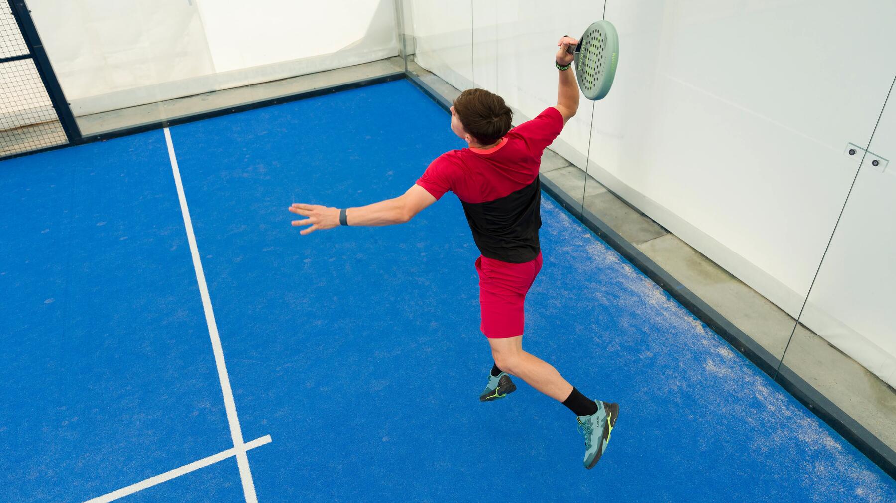 Jongen die een padel smash slaat