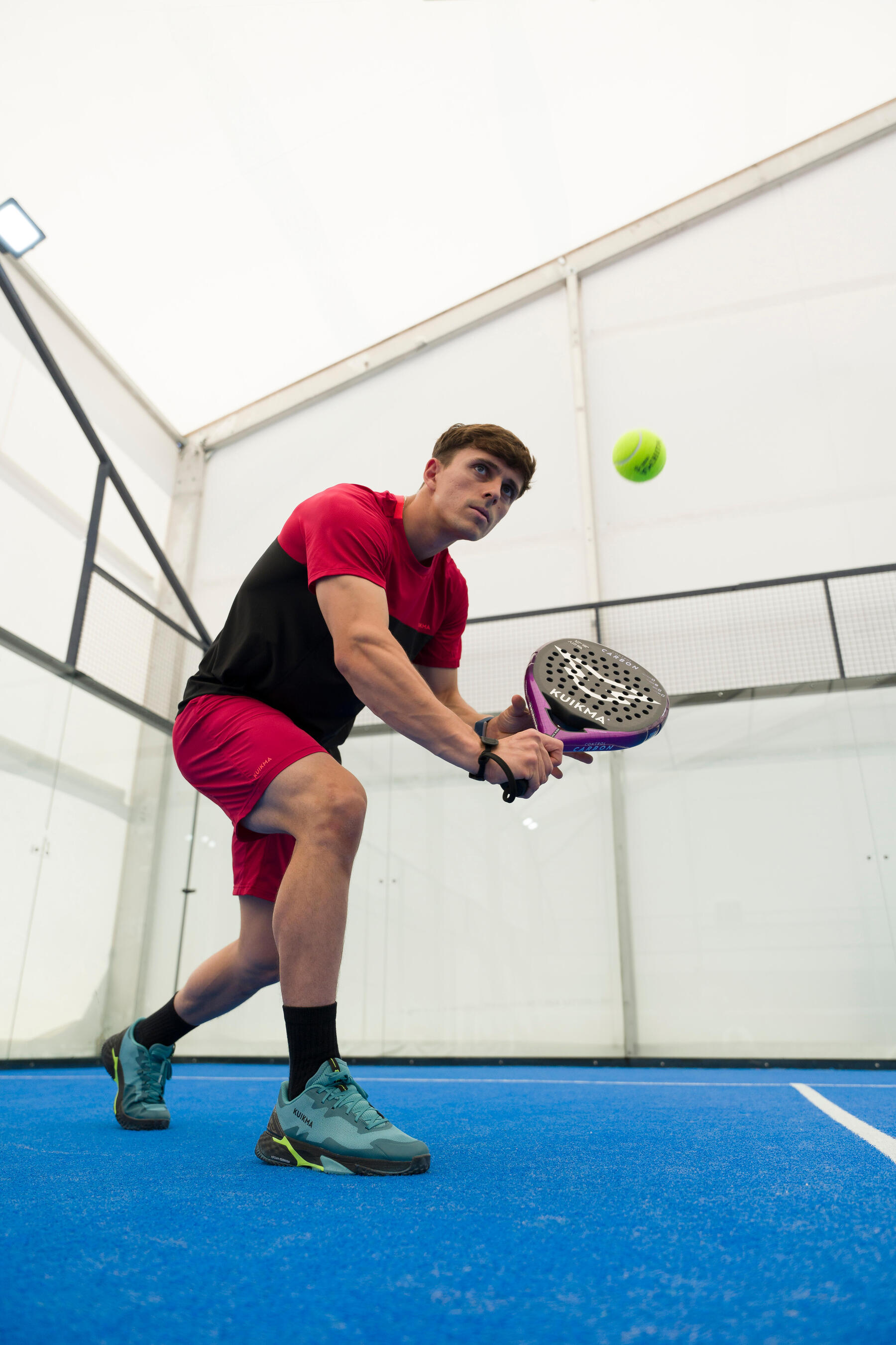 Jongeman is aan het padellen en slaat een volley