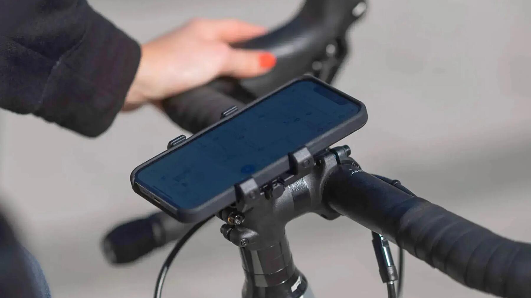 Kobieta trzymająca kierownicę rowerową z zamontowanym uchwytem rowerowym na telefon