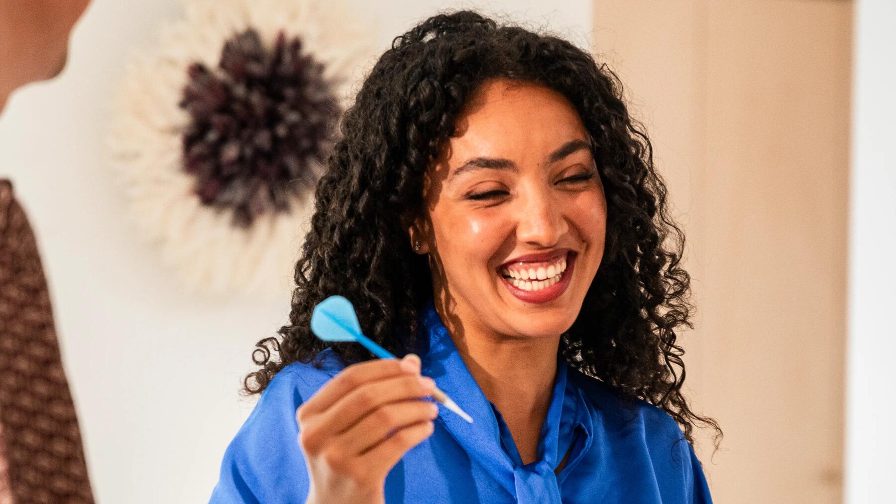 Vrouw houdt een dartpijl vast