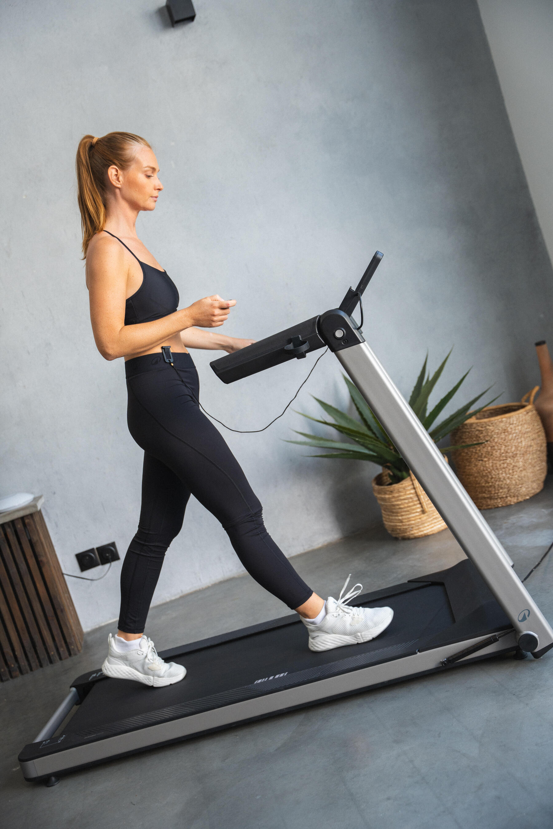 Eine Frau startet mit dem laufen auf dem Laufband als Anfängerin