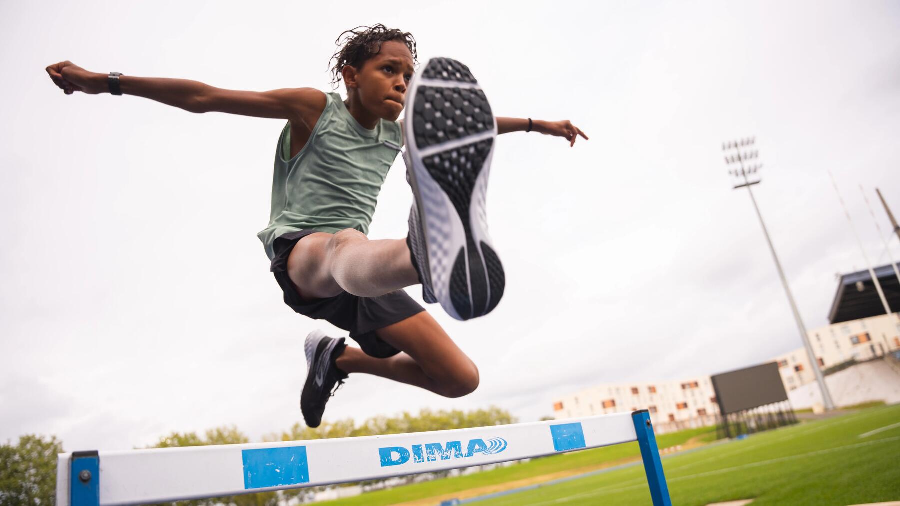 Ein Junge springt mit Spikes an den Leichtathletikschuhen