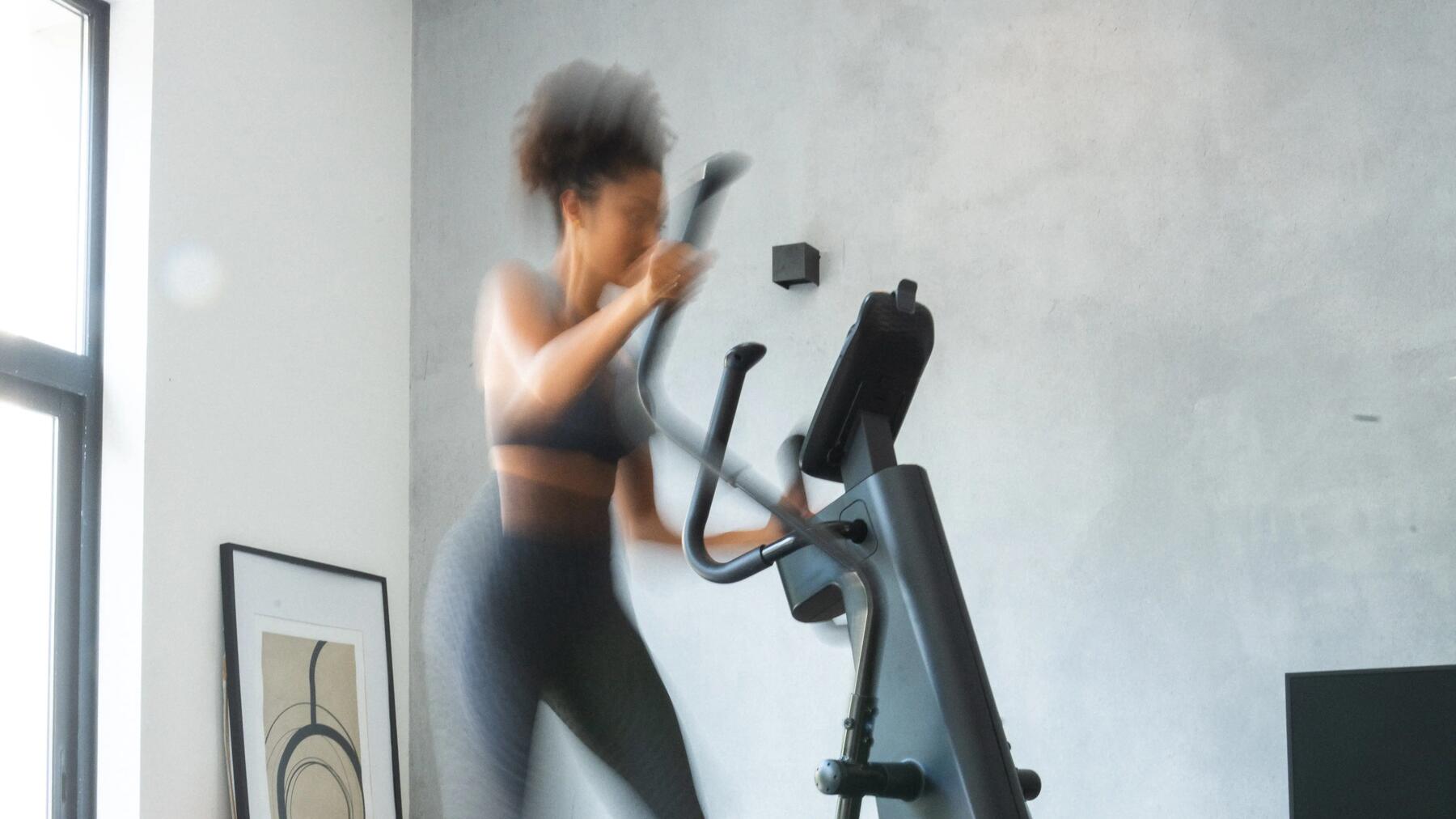 Eine Frau ist gerade dabei, auf dem Crosstrainer zu trainieren
