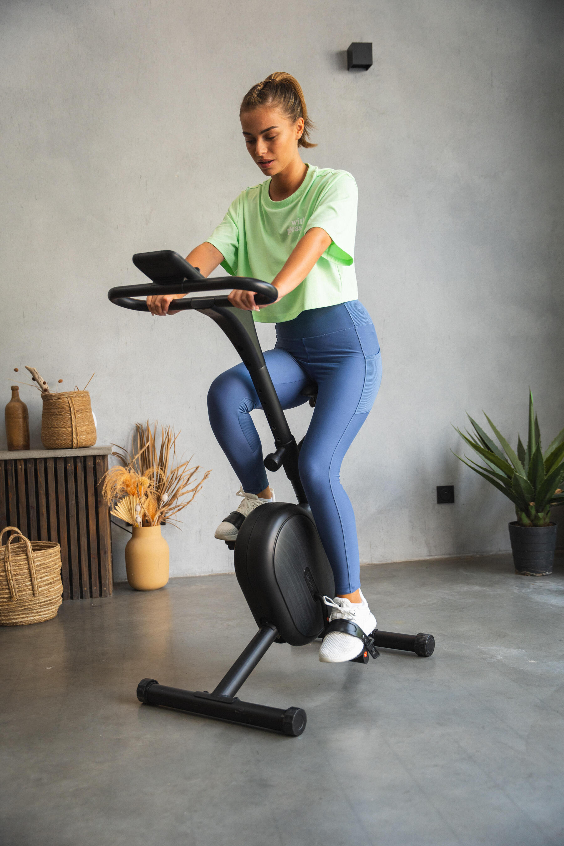 Kobieta w odzieży sportowej ćwicząca na rowerze stacjonarnym