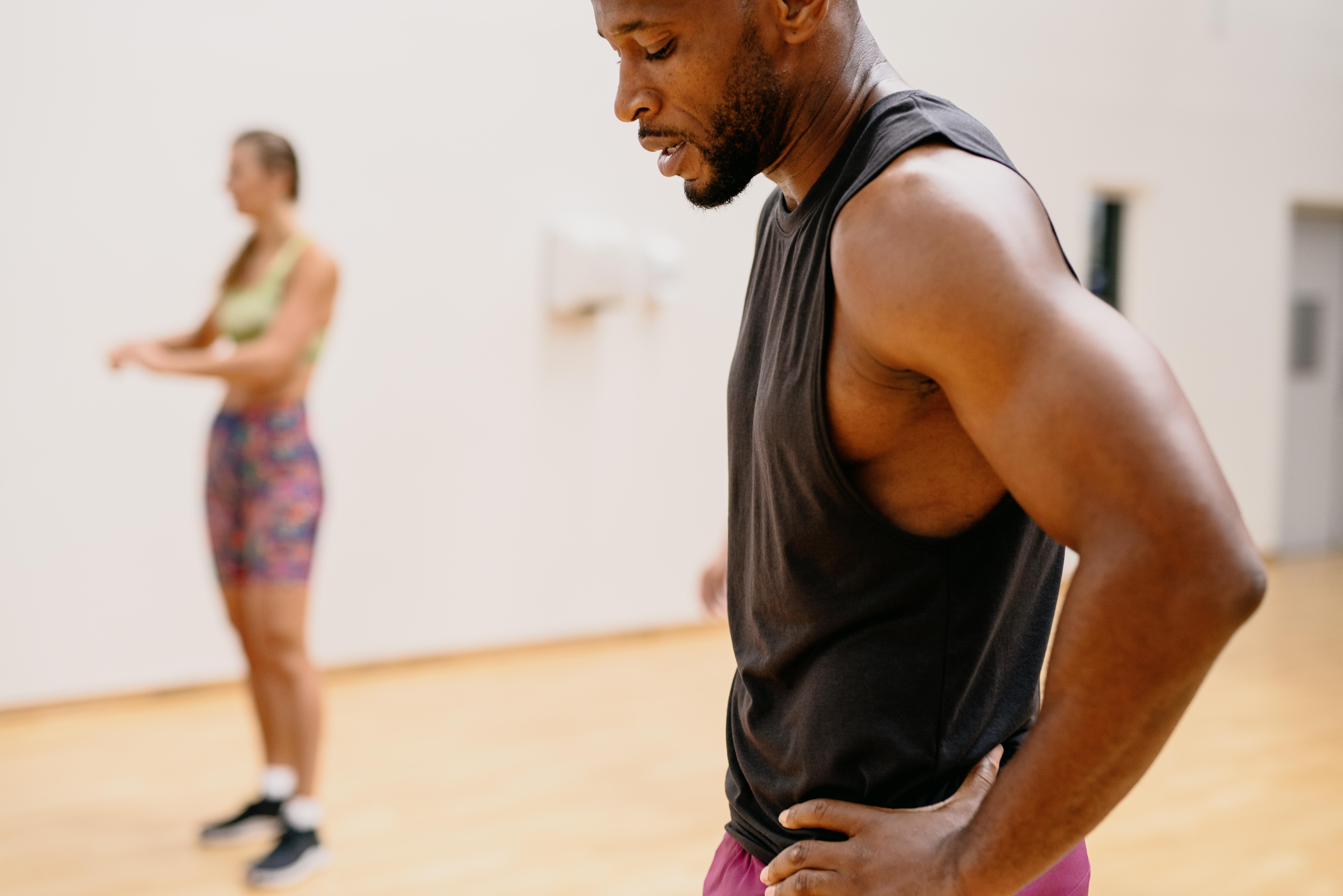Man wearing a black tank top during a gym workout