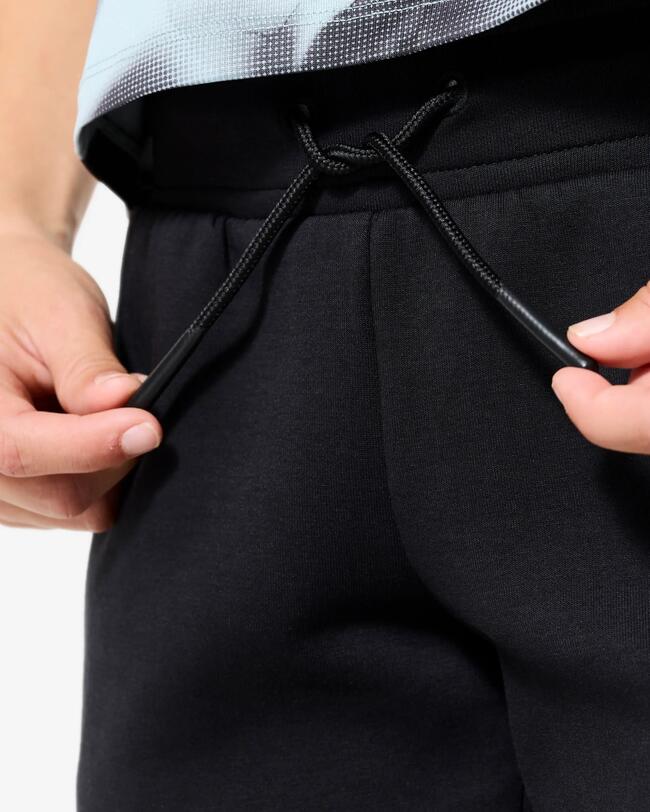 Junge zeigt vorderen Kordelzug an der Jogginghose