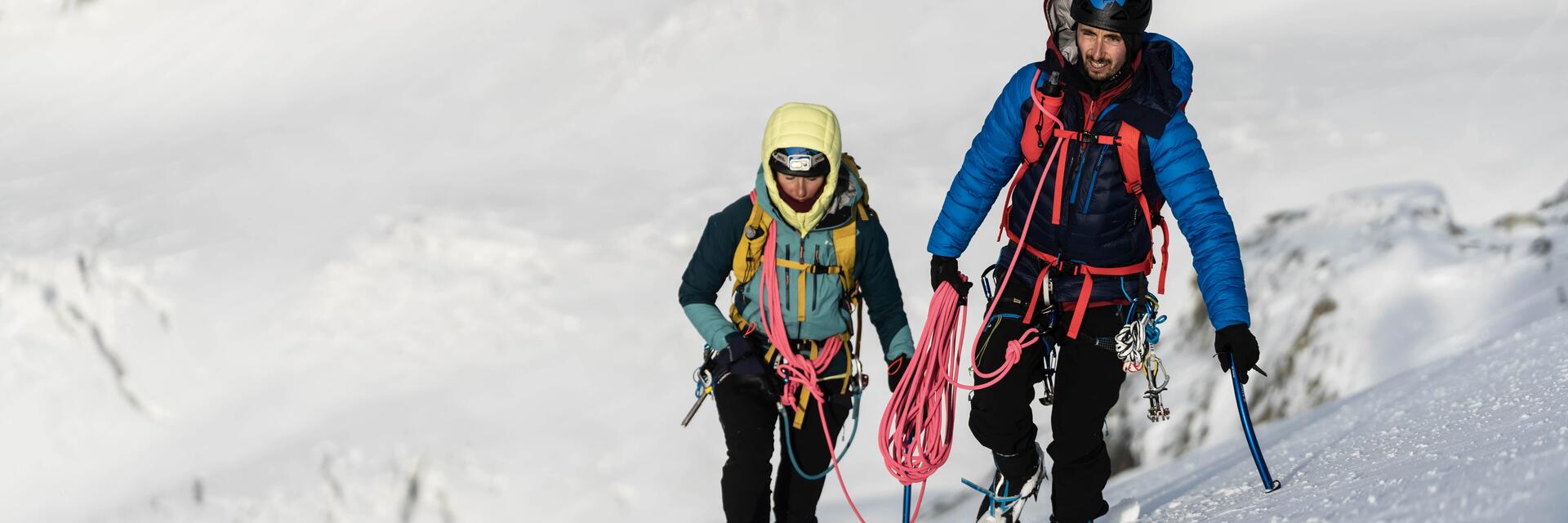 Alpiniści ze sprzętem i plecakiem lawinowym na plecach wspinający się pod górę