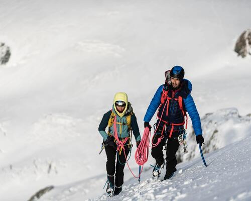 Alpiniści ze sprzętem i plecakiem lawinowym na plecach wspinający się pod górę
