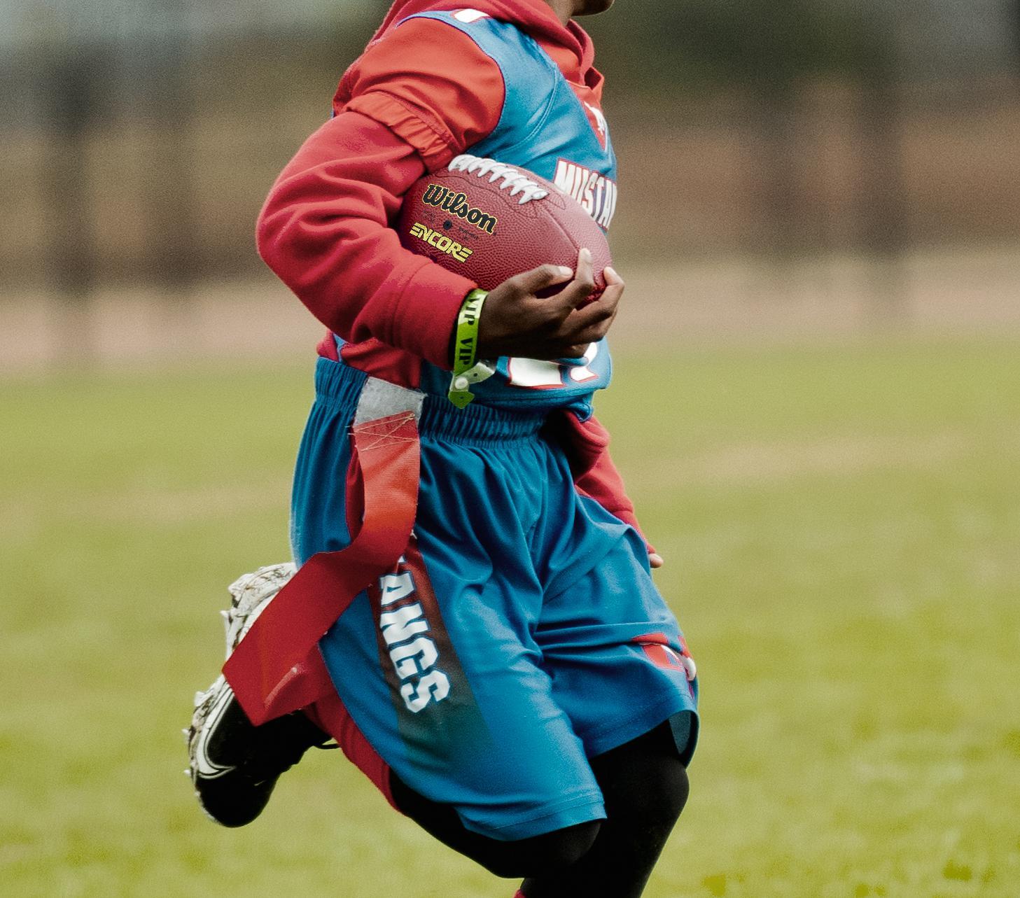 Junge erzielt einen Touchdown im American Football.