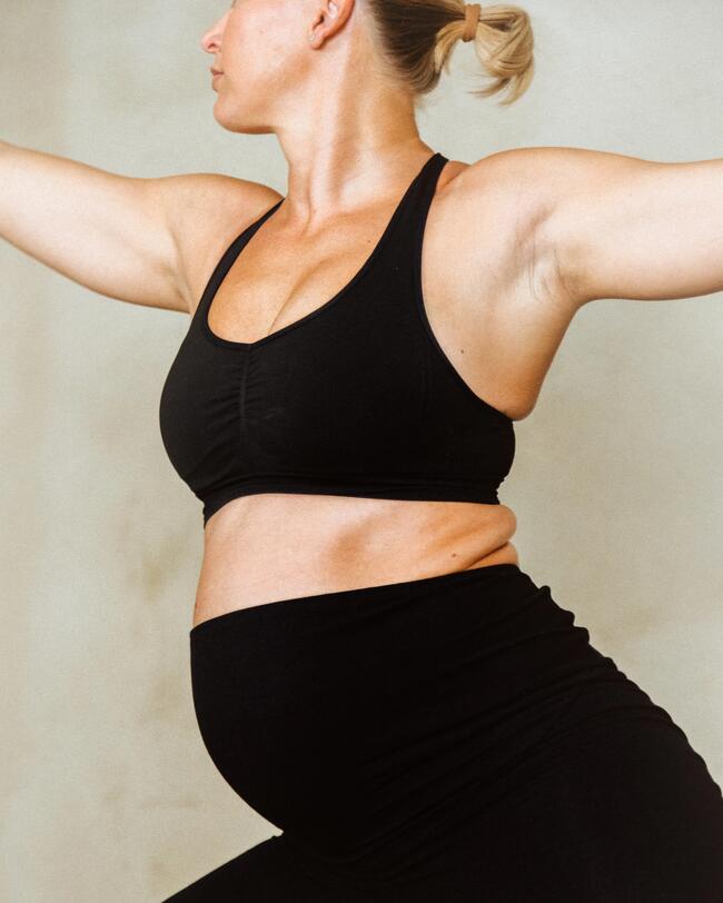 Eine schwangere Frau macht Yoga.
