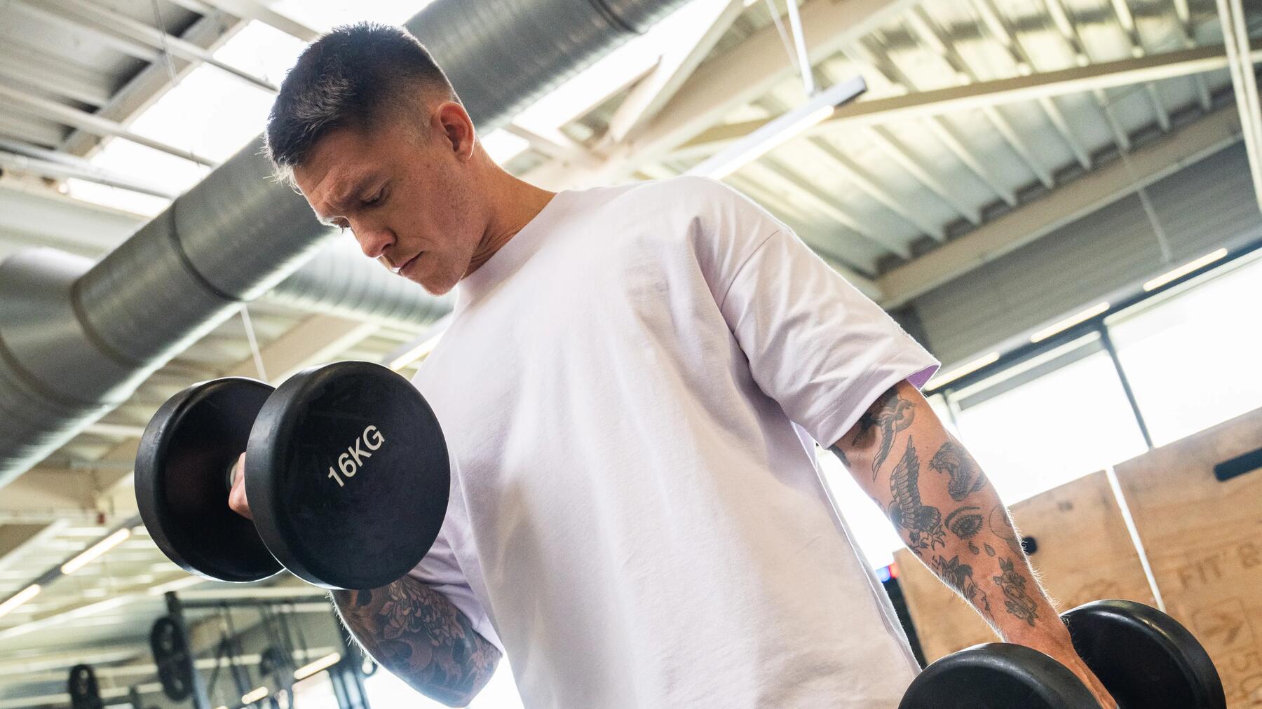 hombre haciendo curl de biceps con mancuernas