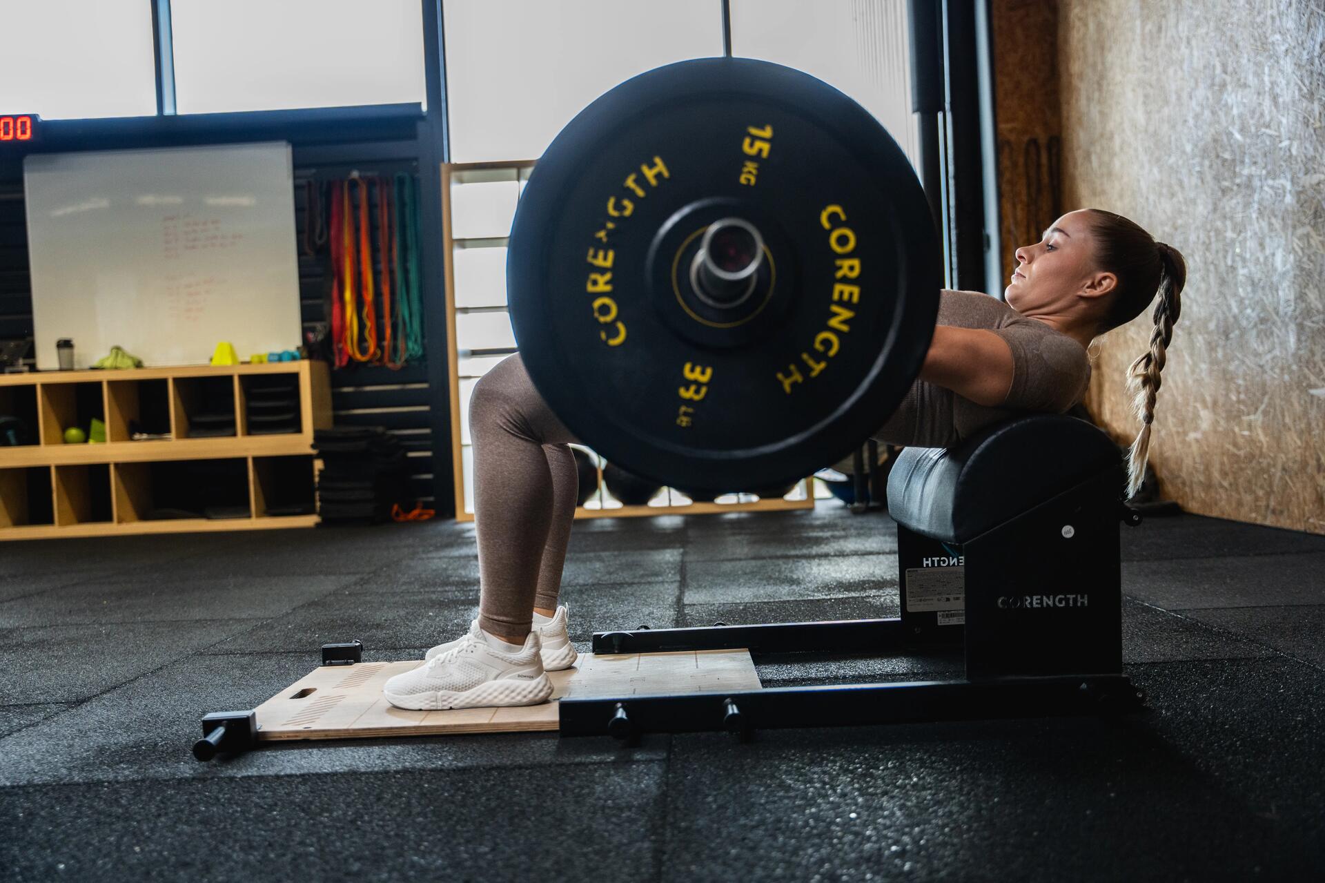Kobieta w stroju sportowym ćwicząca hip thrust na siłowni