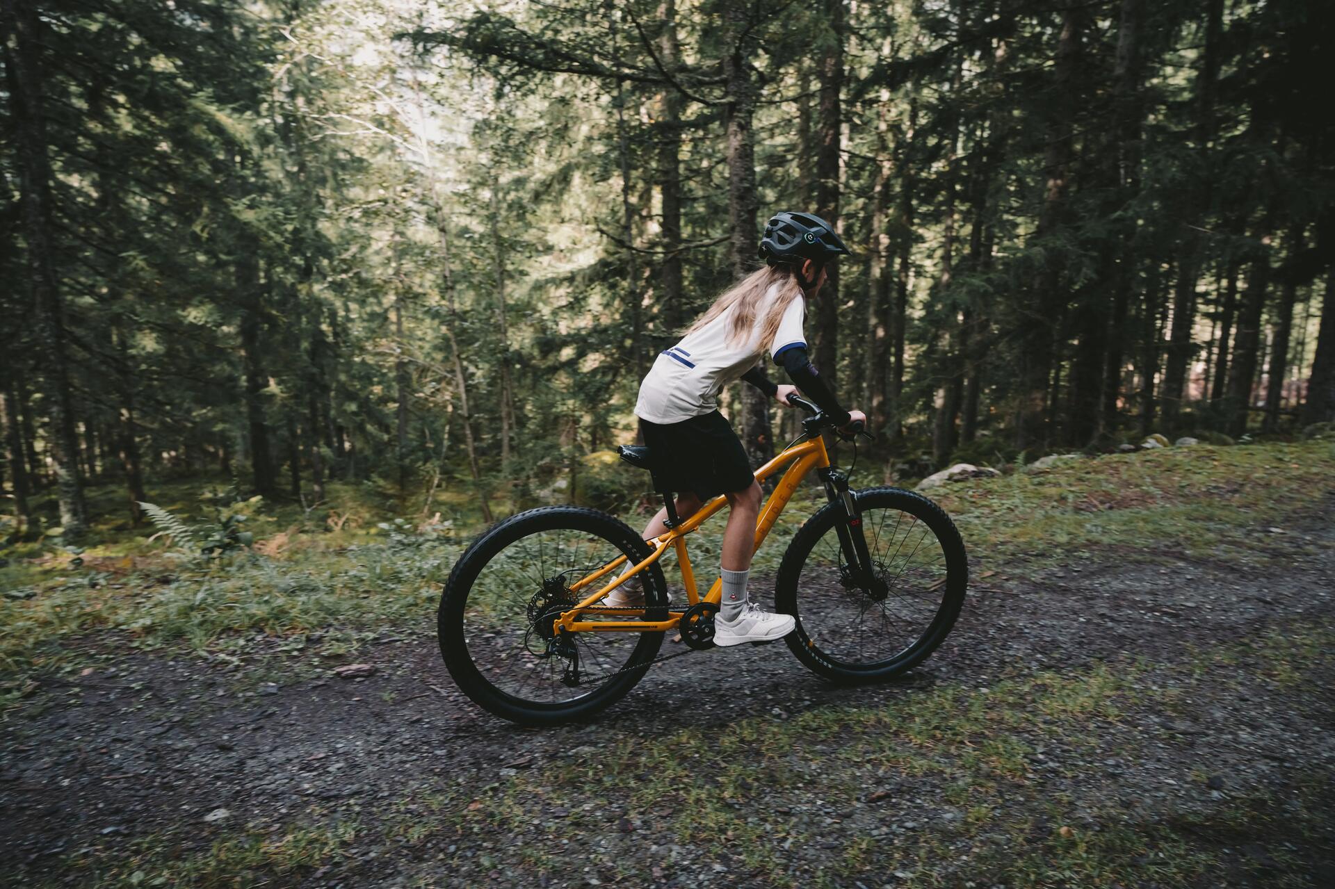 VTT_enfant_24_pouces_jaune_sur_un_sentier_en_forêt