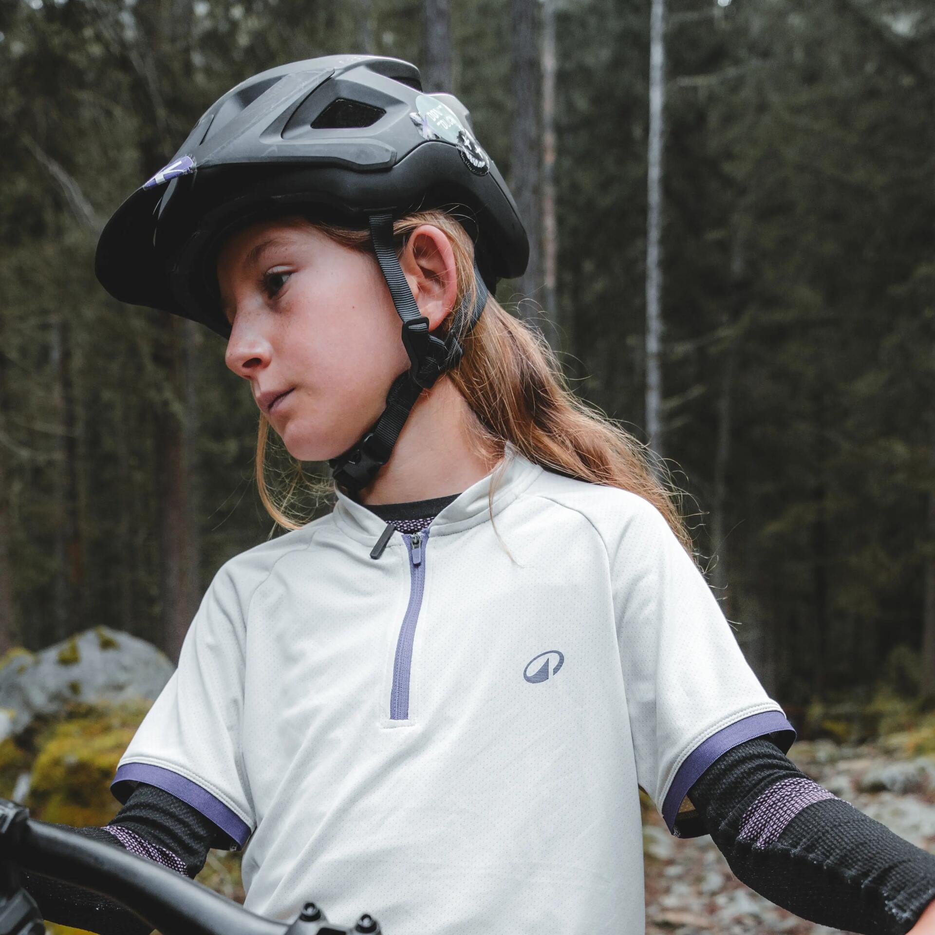 Enfant en forêt sur un vtt portant un casque