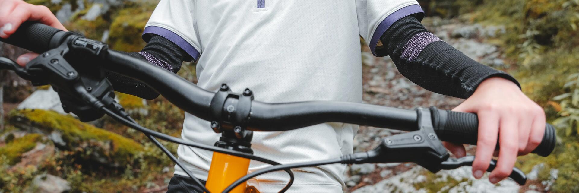Dziewczynka w kasku trzymająca się kierownicy mtb stojąca na rowerze