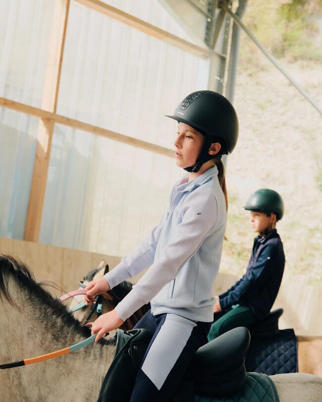 Little girl on a horse wearing a 520 helmet