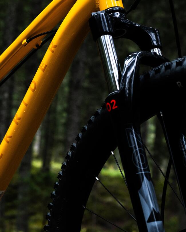 Detailaufnahme Vorderrad gelbes Mountainbike mit Federgabel und profilierten Reifen
