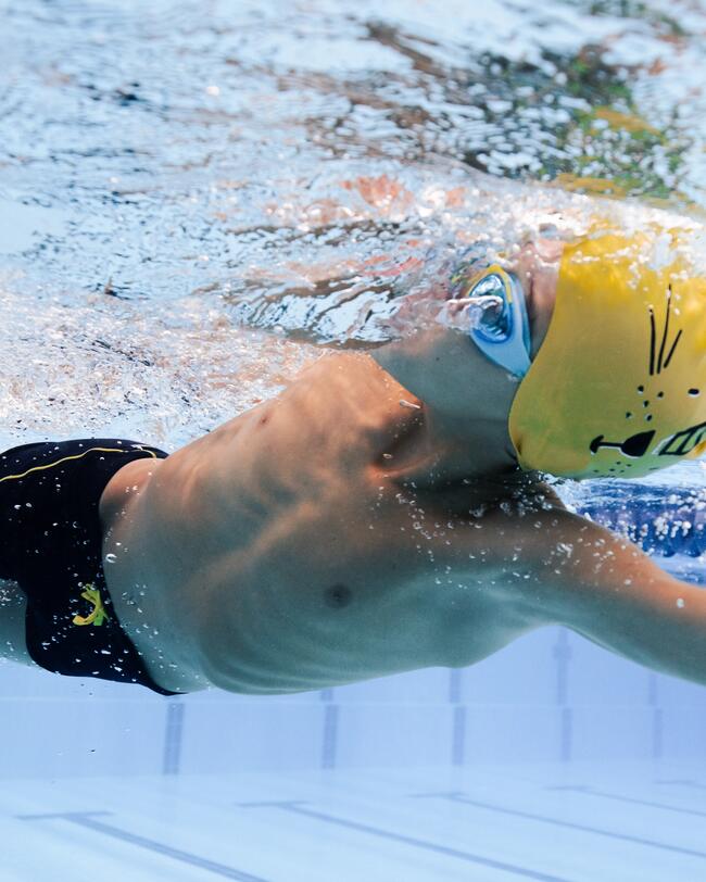 Junge beim Schwimmen im Schwimmbecken, Badekappe, Schwimmbrille, Badehose