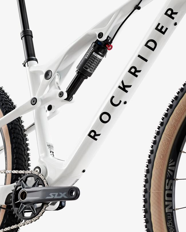 Weißes Mountainbike mit schwarzen und beigen Elementen, große schwarze Schrift, grobstollige Reifen, mattes Rahmendesign, sichtbare Federgabel