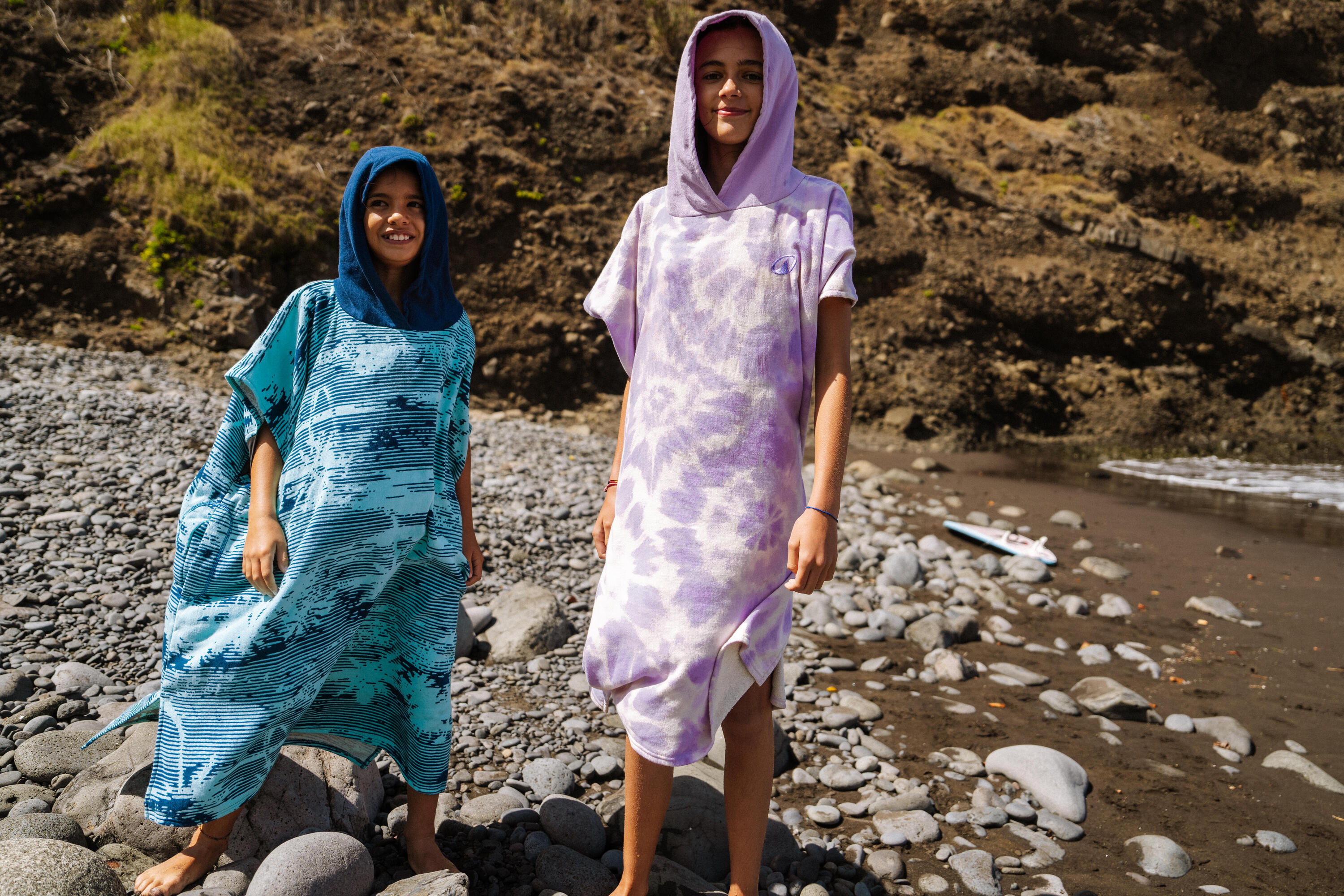 Zwei Kinder in Surfponchos am Strand