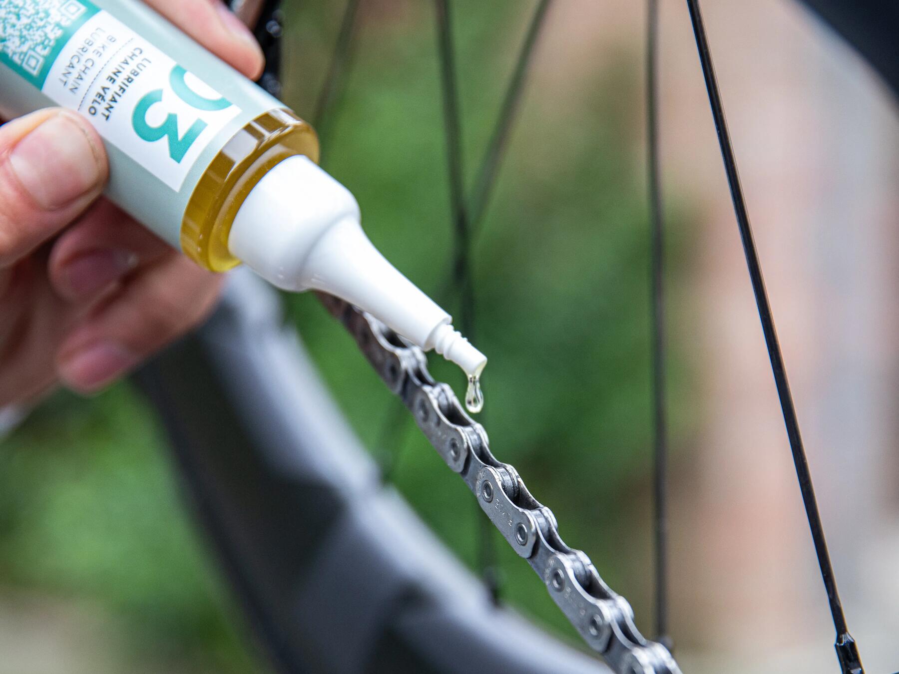 Kettingolie van Decathlon wordt aangebracht op een fietsketting