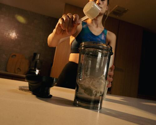 Femme tenant un shaker de whey