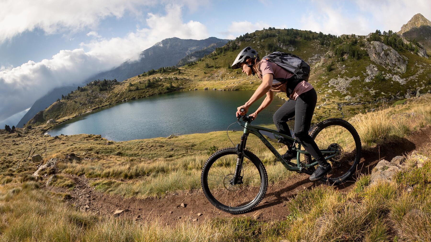 Kobieta w kasku rowerowym jadąca na rowerze marki Rockrider