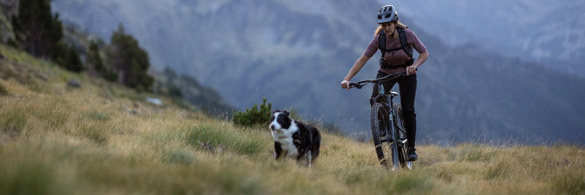 Kobieta w kasku rowerowym jadąca na rowerze górskim marki Rockrider