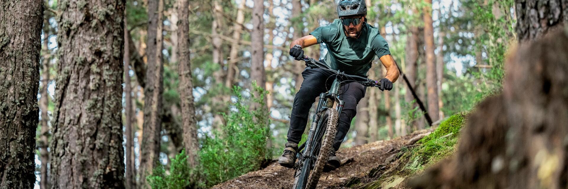 Mężczyzna zjeżdżający rowerem MTB z góry w odzieży rowerowej