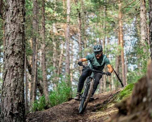 Mężczyzna zjeżdżający rowerem MTB z góry w odzieży rowerowej