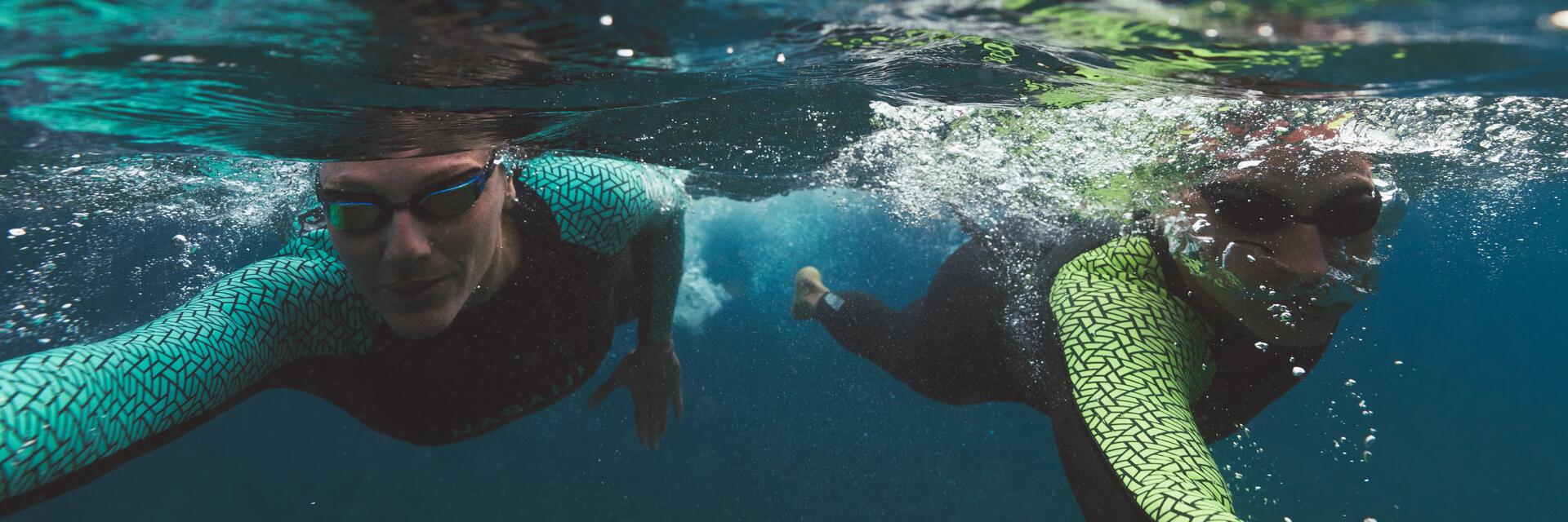 Zwei Personen praktizieren Freiwasserschwimmen im Meer