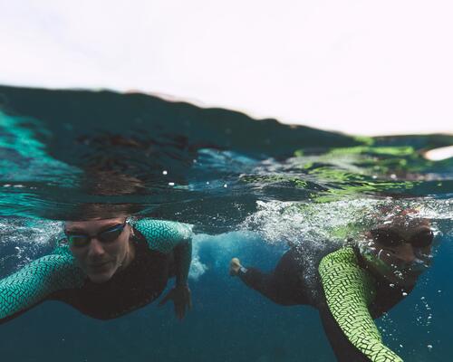 Zwei Personen praktizieren Freiwasserschwimmen im Meer