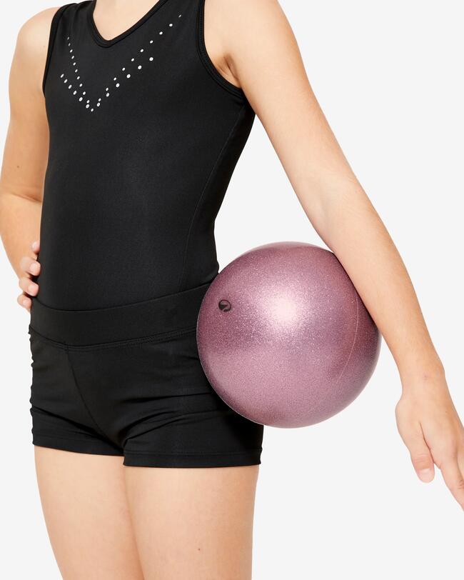 Ein Mädchen hat einen Gymnastikball unter dem Arm.