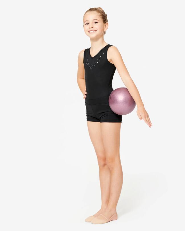 Ein Mädchen hat einen Gymnastikball unter dem Arm.