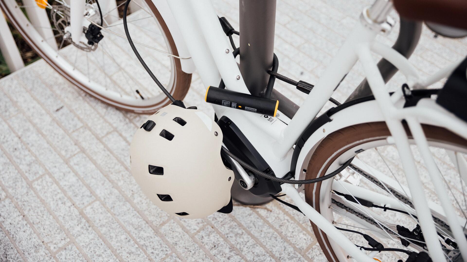 Een fiets die zowel aan het frame is vastgemaakt als aan de twee wielen met een kabelslot en een beugelslot