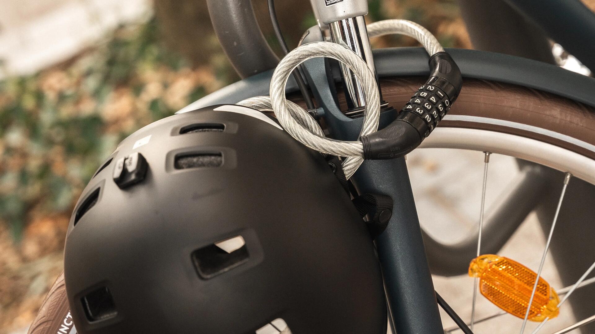Een fiets waaraan een helm is vastgemaakt met een kabelslot