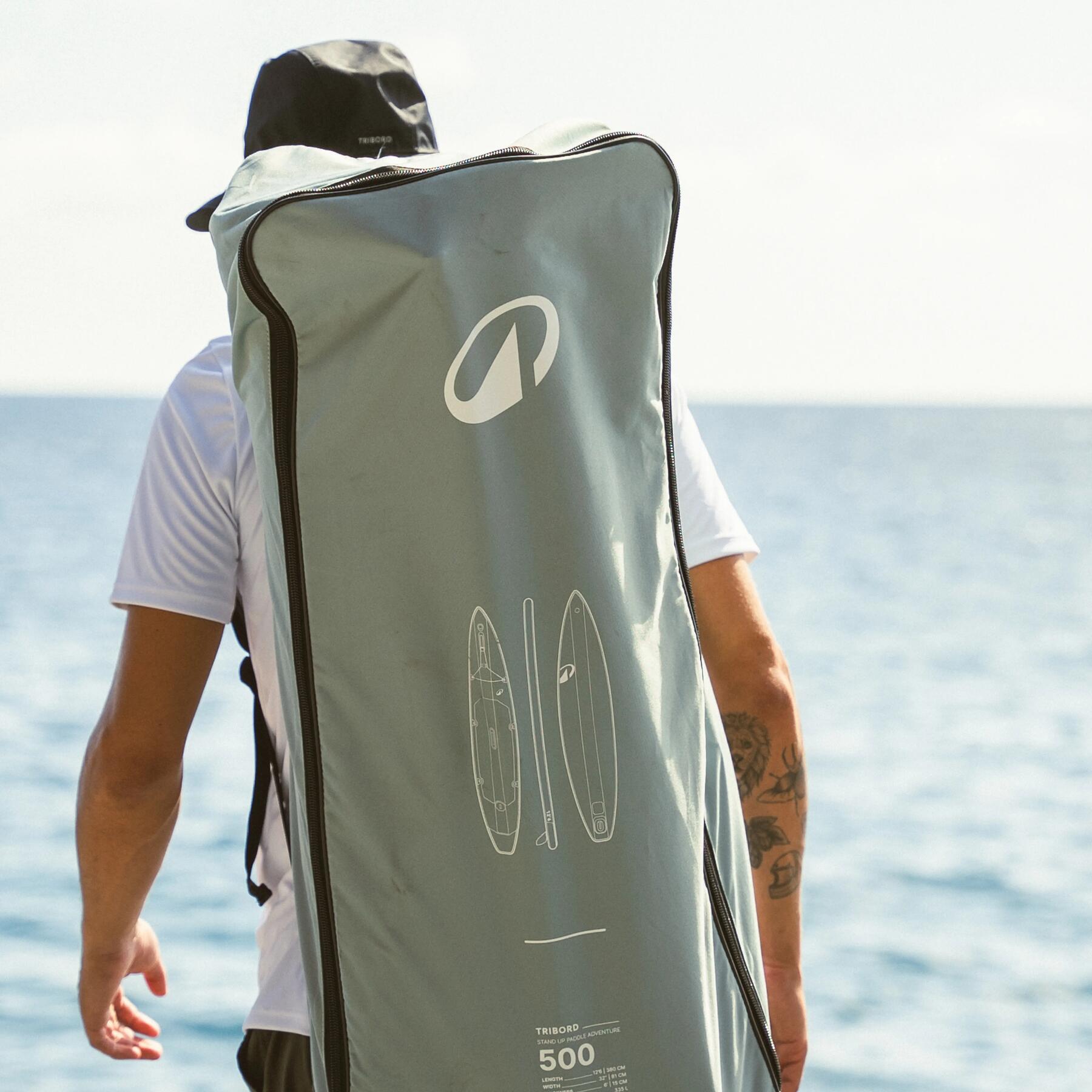 hombre transportando tabla paddle surf 