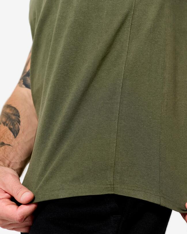 Detailaufnahme der unteren Saumkante eines olivgrünen T-Shirts, gehalten von Händen mit Tätowierungen.