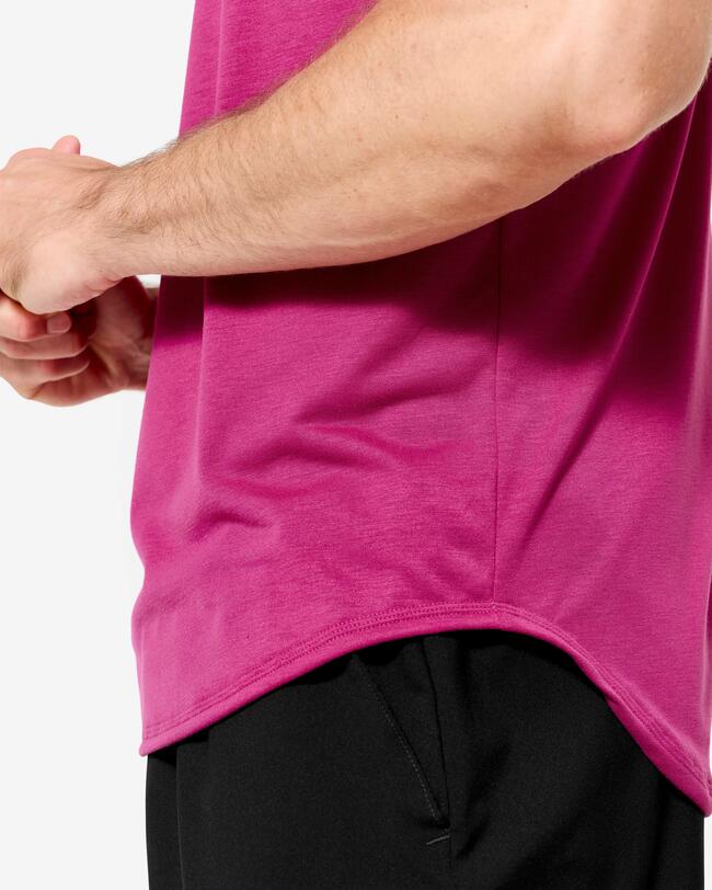 Nahaufnahme eines Mannes in magentafarbenem Tanktop und schwarzen Shorts mit abgerundetem Saum.