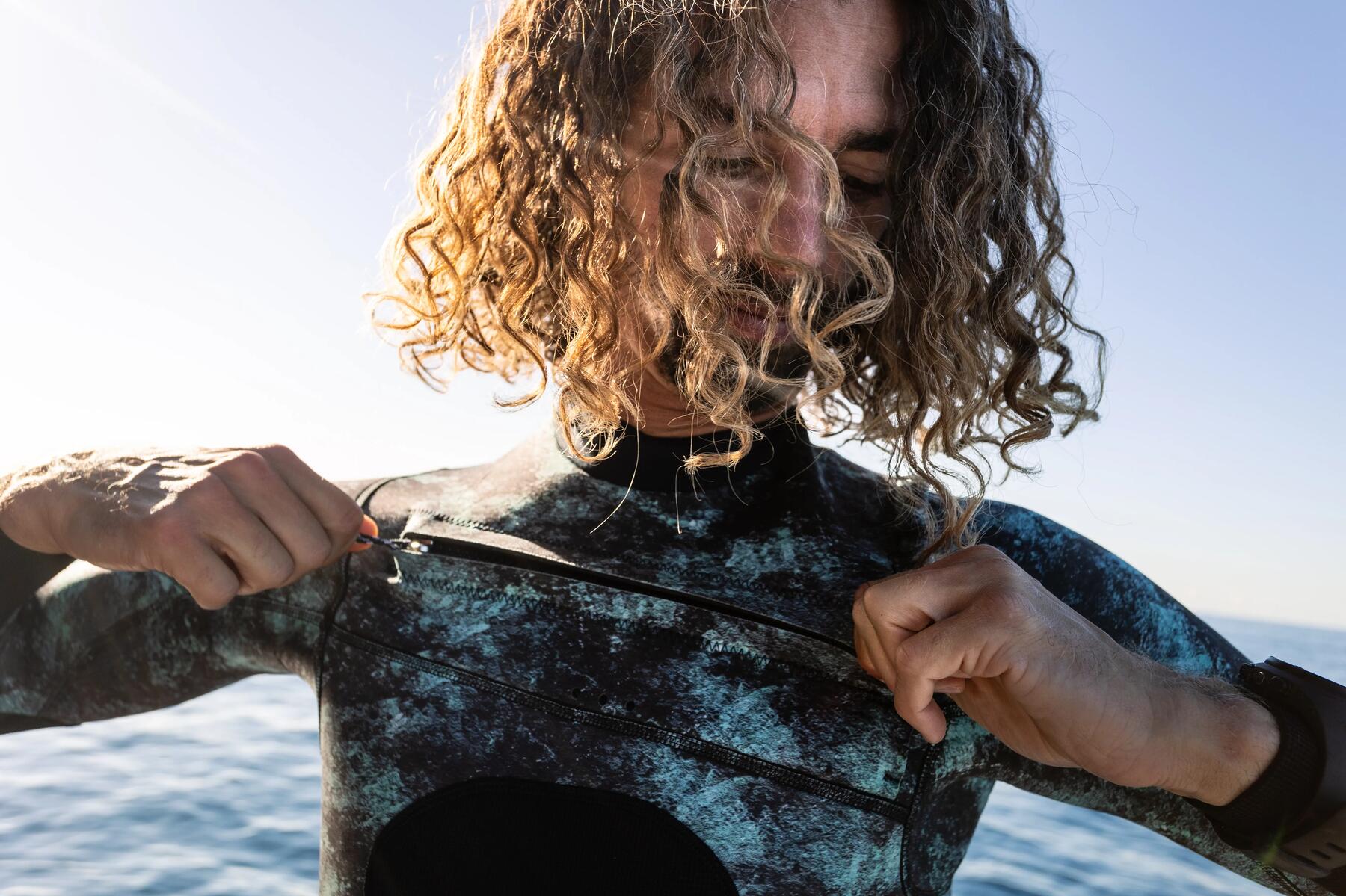 hombre poniendose el traje de neopreno