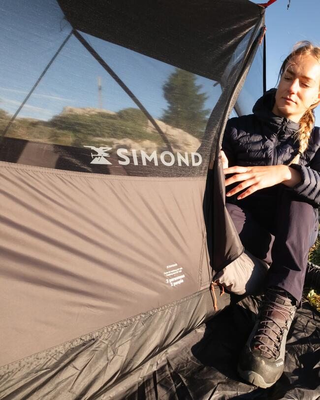 Person hält Zelt von außen, Schriftzug Simond zu sehen