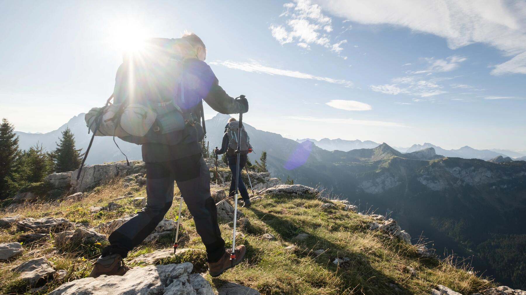 Eine Person hat Trekkingstöcke auf dem Berg in der Sonne