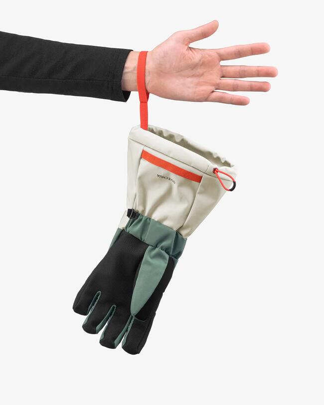 Skihandschuh Kinder warm wasserdicht - 500 lang grün hängt an der Handschlaufe am Handgelenk eines Kindes.