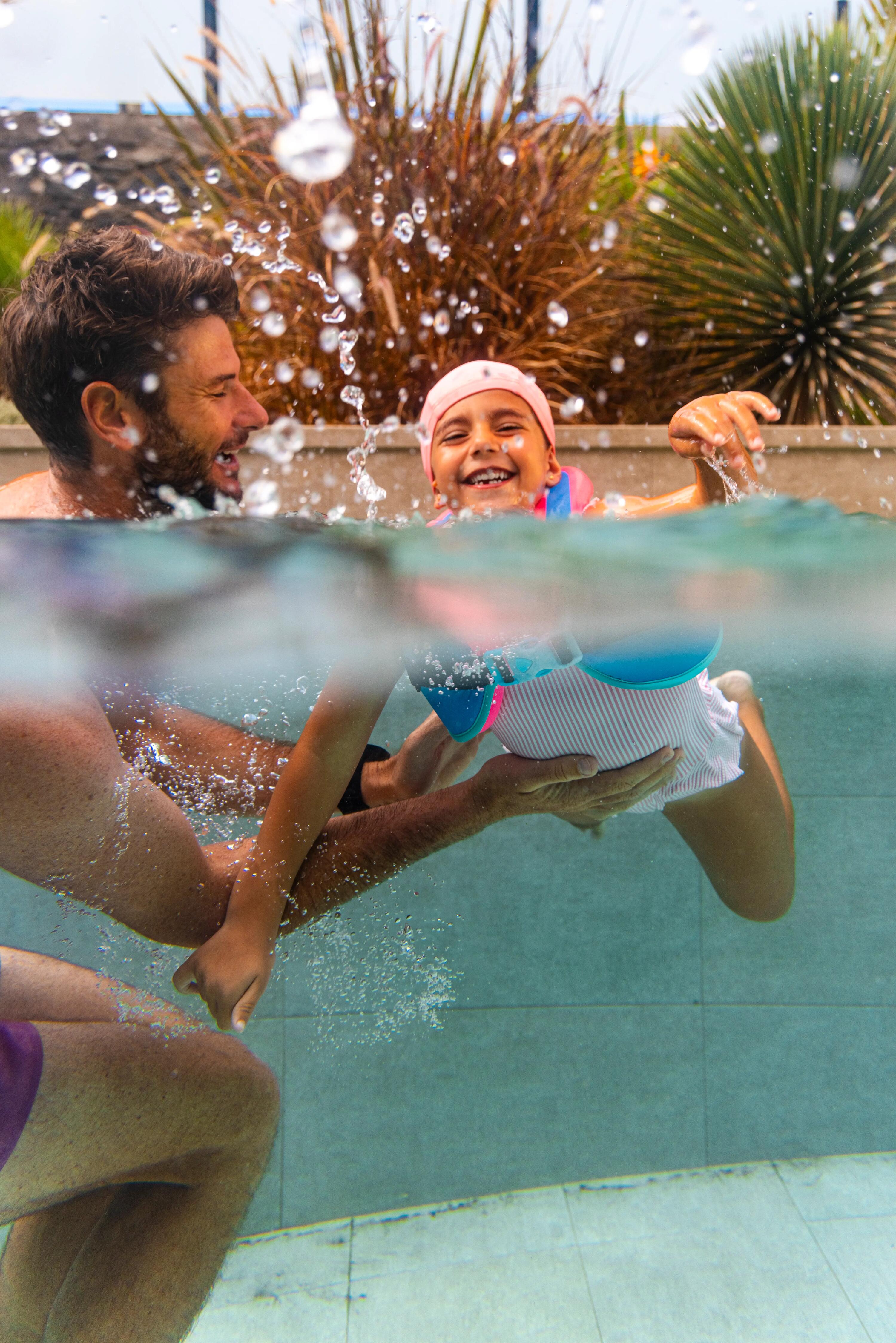 Kind schwimmt mit Schwimmflügeln und Sonnenbrille